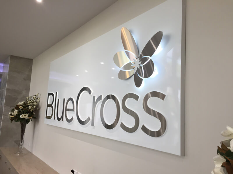 blue cross metal wall logo with name